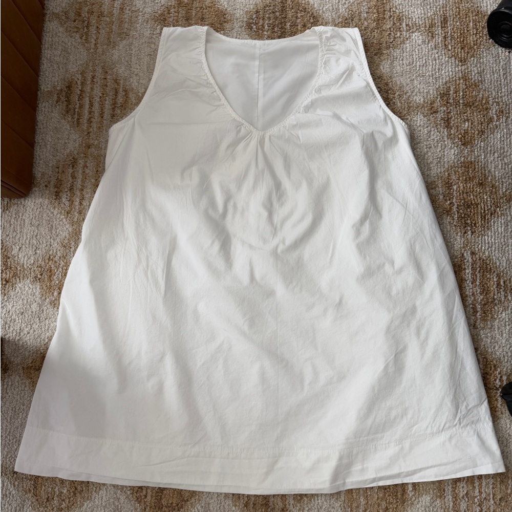 White Sleeveless V-Neck Cotton mini dress with side pockets.